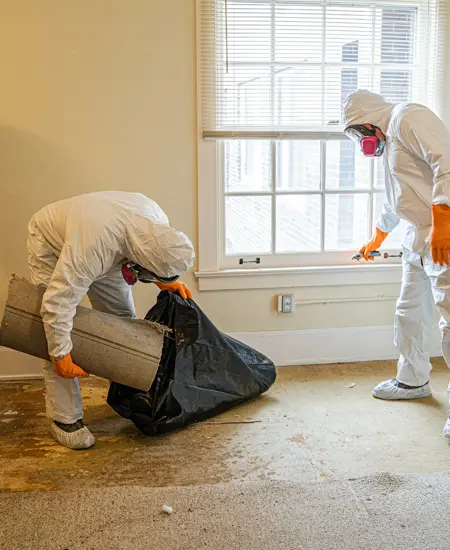 Hazmat workers bagging a dirty carpet