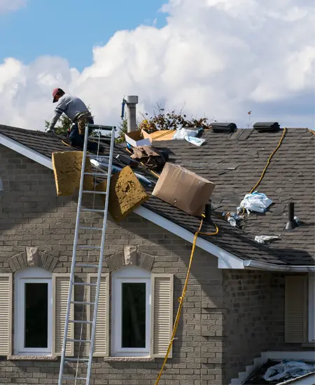 Man working on roof surrounded by construction supplies